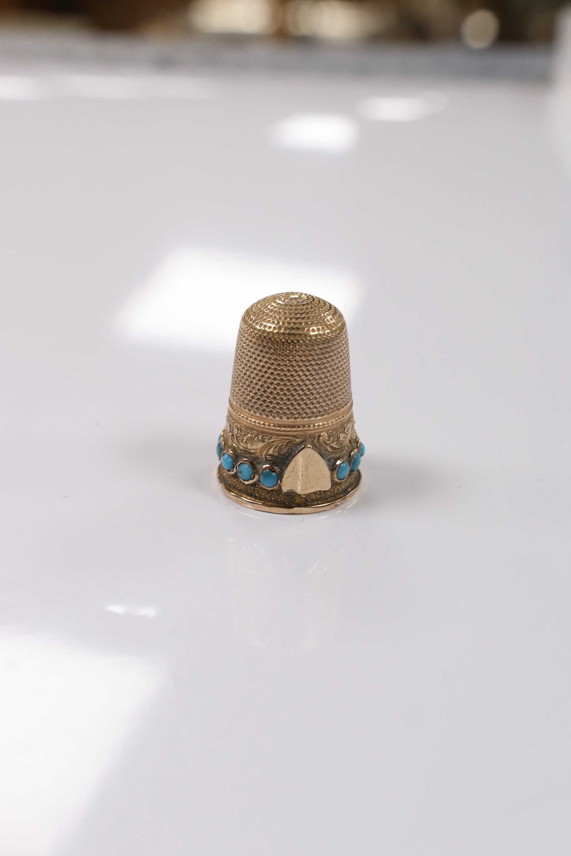 An antique yellow metal and turquoise set thimble, (stone missing), 21mm, gross weight 4,5 grams. Condition - poor to fair